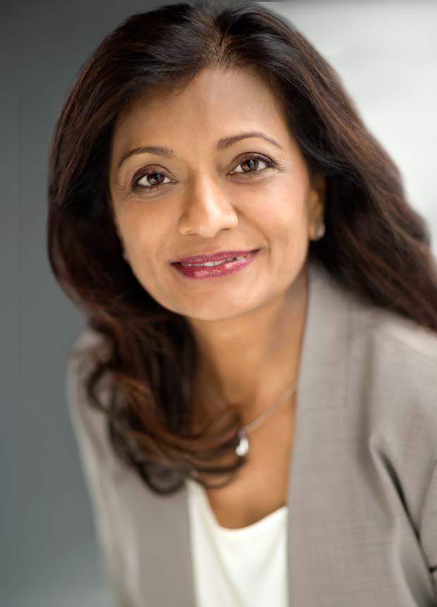 Shows a professional business headshot of a woman wearing gray jacket