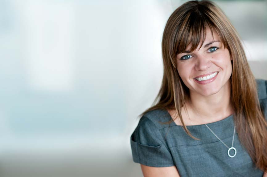 Shows a professional business headshot of a woman, casual, landscape, light ambient background
